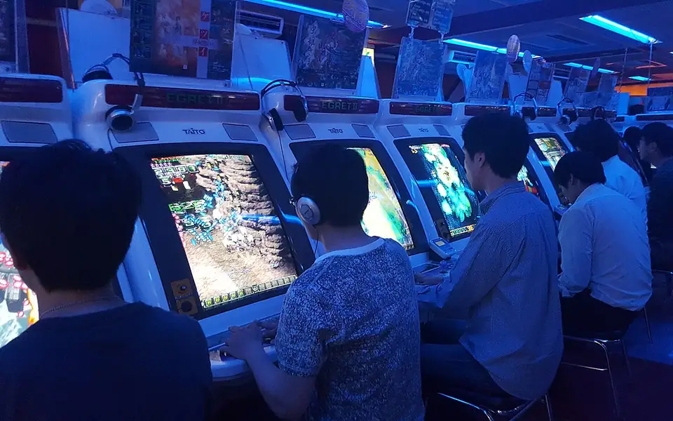 Players at arcade cabinets, similar in feel to fishing games