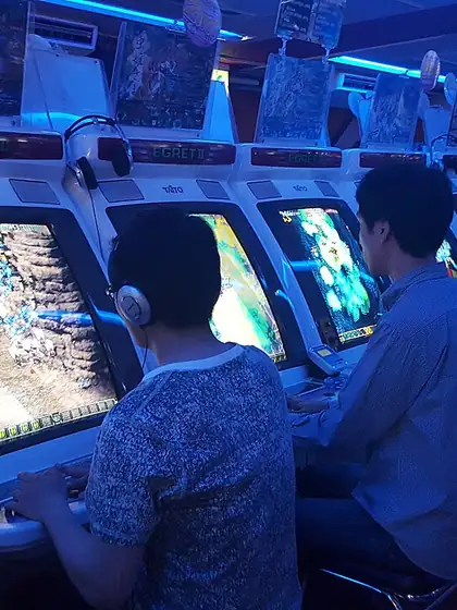 Gamers playing arcade shooting cabinets