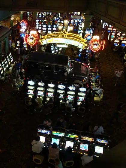 Players seated at rows of bright slot machines